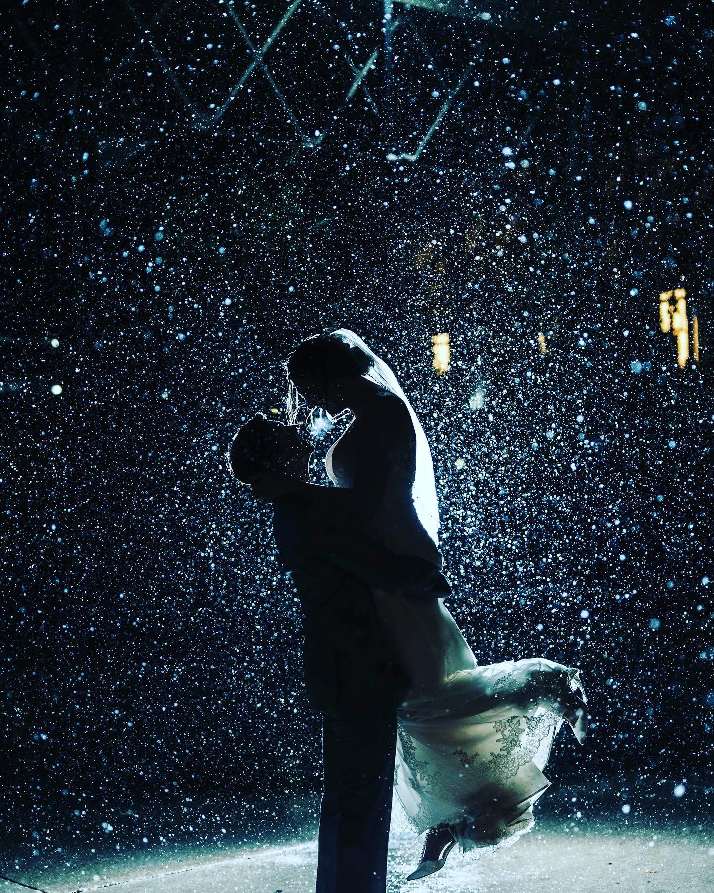 a groom picked up the bride while its raining