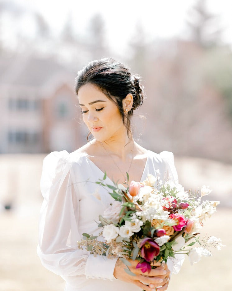 a bride posing in her wedding attire holding the bridal bouquet