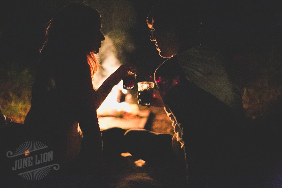 A silhouette of a couple holding drinks as they look at each other