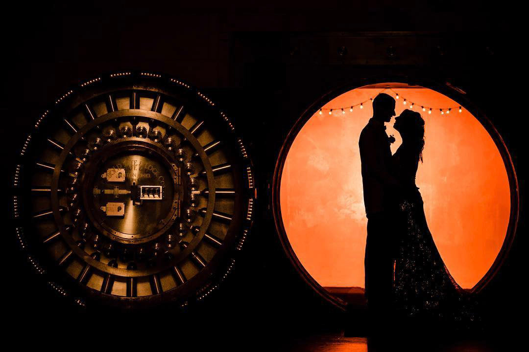 a silhouette image of a couple posing in front of artificial light