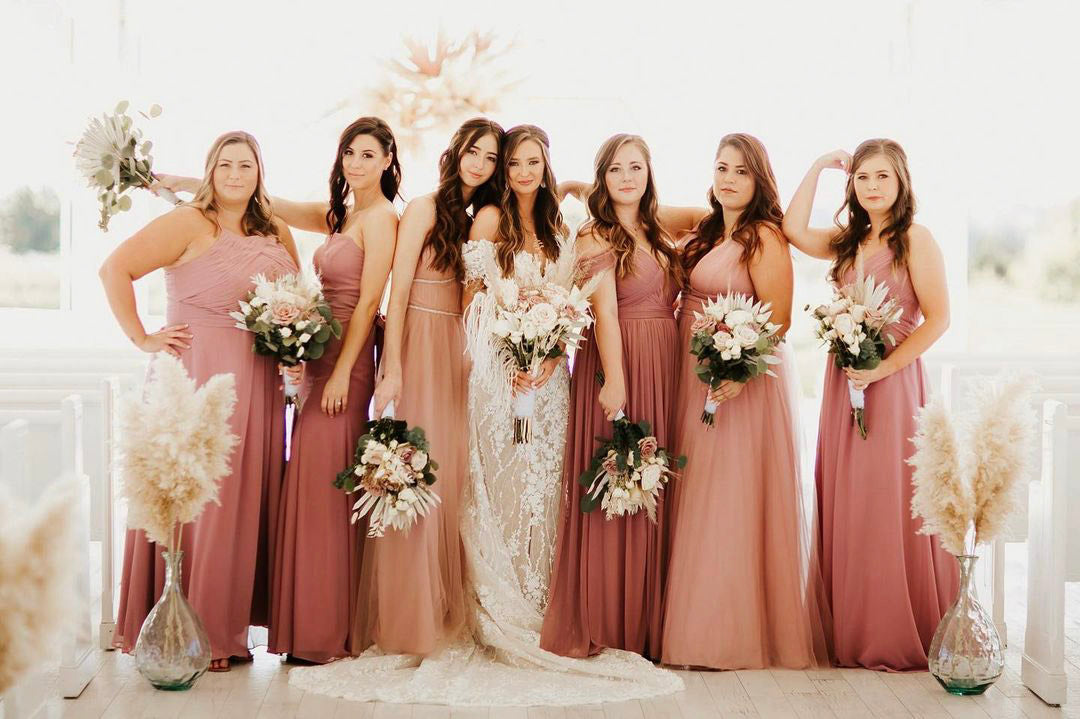 a bride posing with her bridesmaids holding bouquets