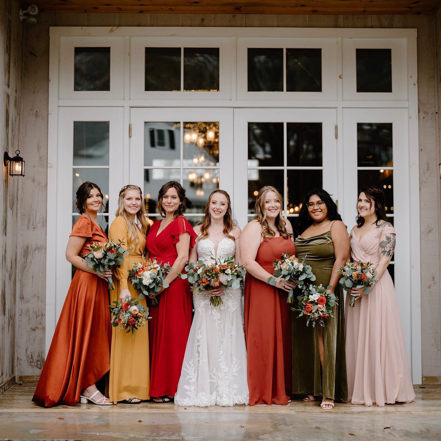 a wedding bride and the bridesmaids standing in front of a white door