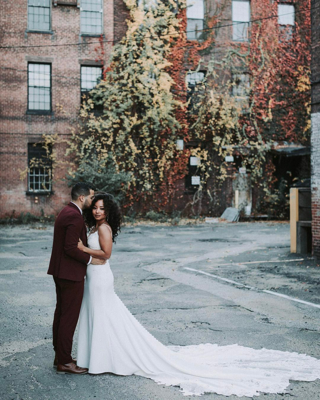 a couple posing in their wedding attire on the porch of a beautiful mansion