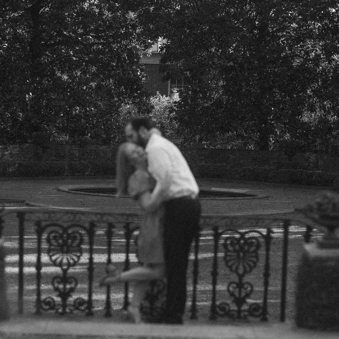 a grainy image of a groom hugging the bride on the balcony