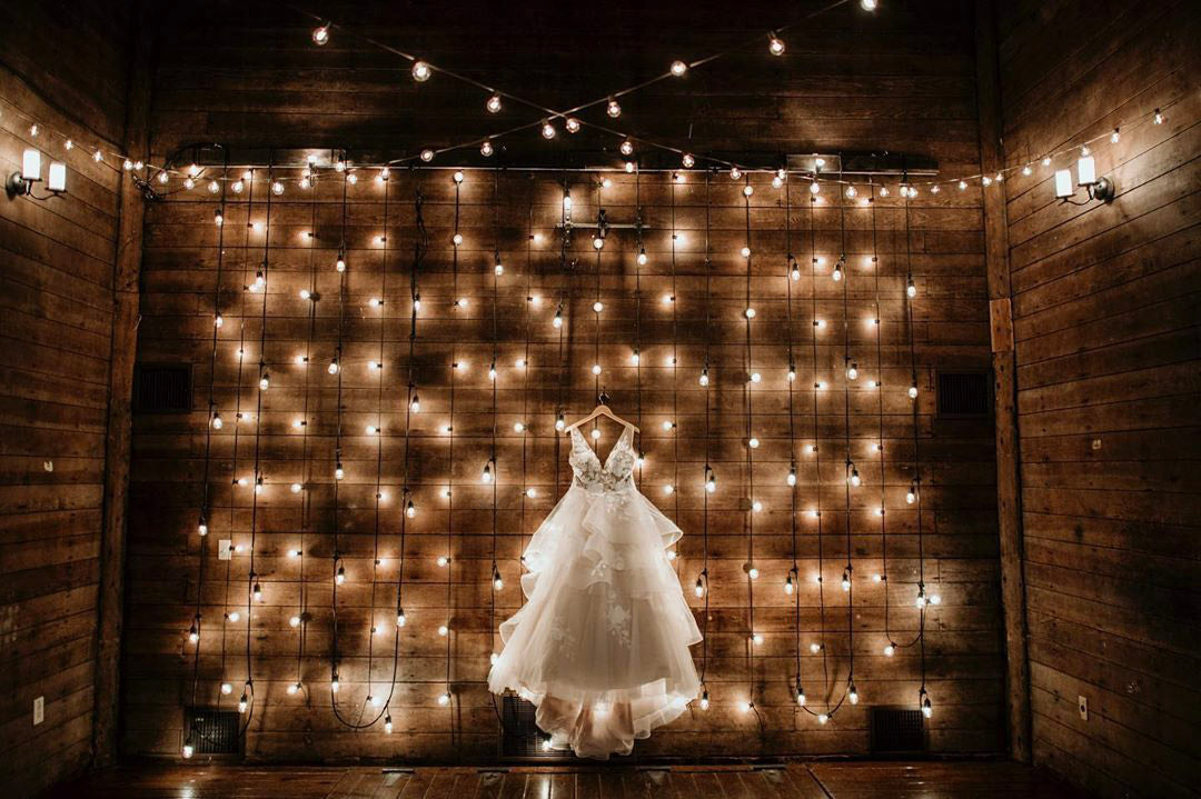 a bridal wedding dress hanging with lots of light in the background