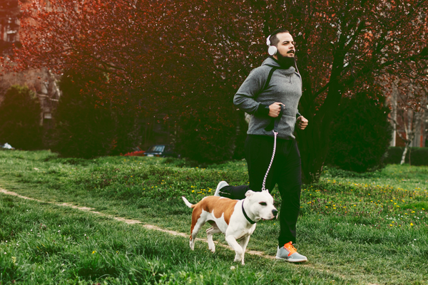 Man jogging in park with dog