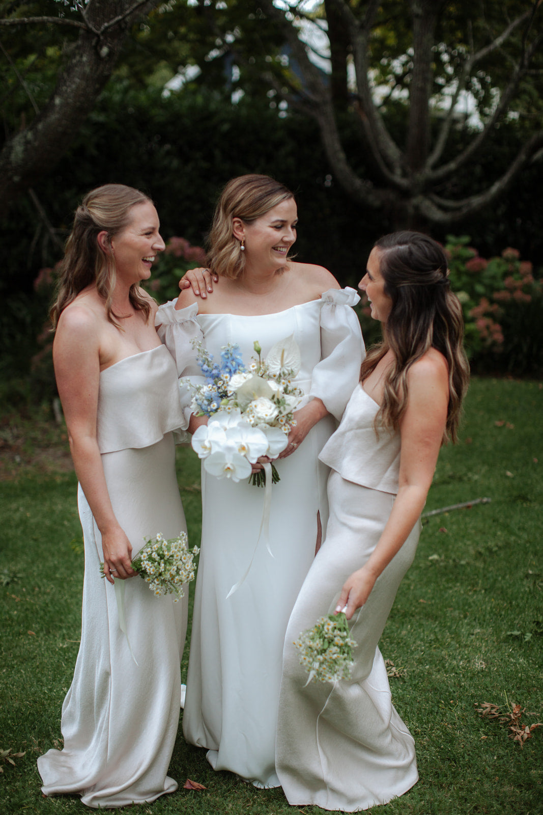 bride with bridesmaids white dresses blue flowers garden wedding