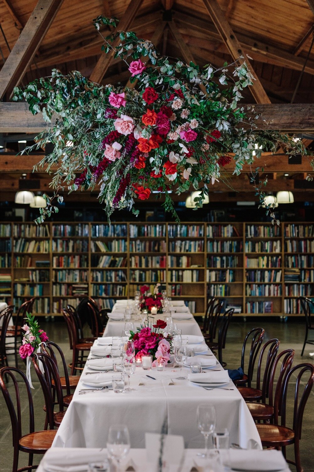 inside bendooley book barn estate wedding reception floral installation ceiiling