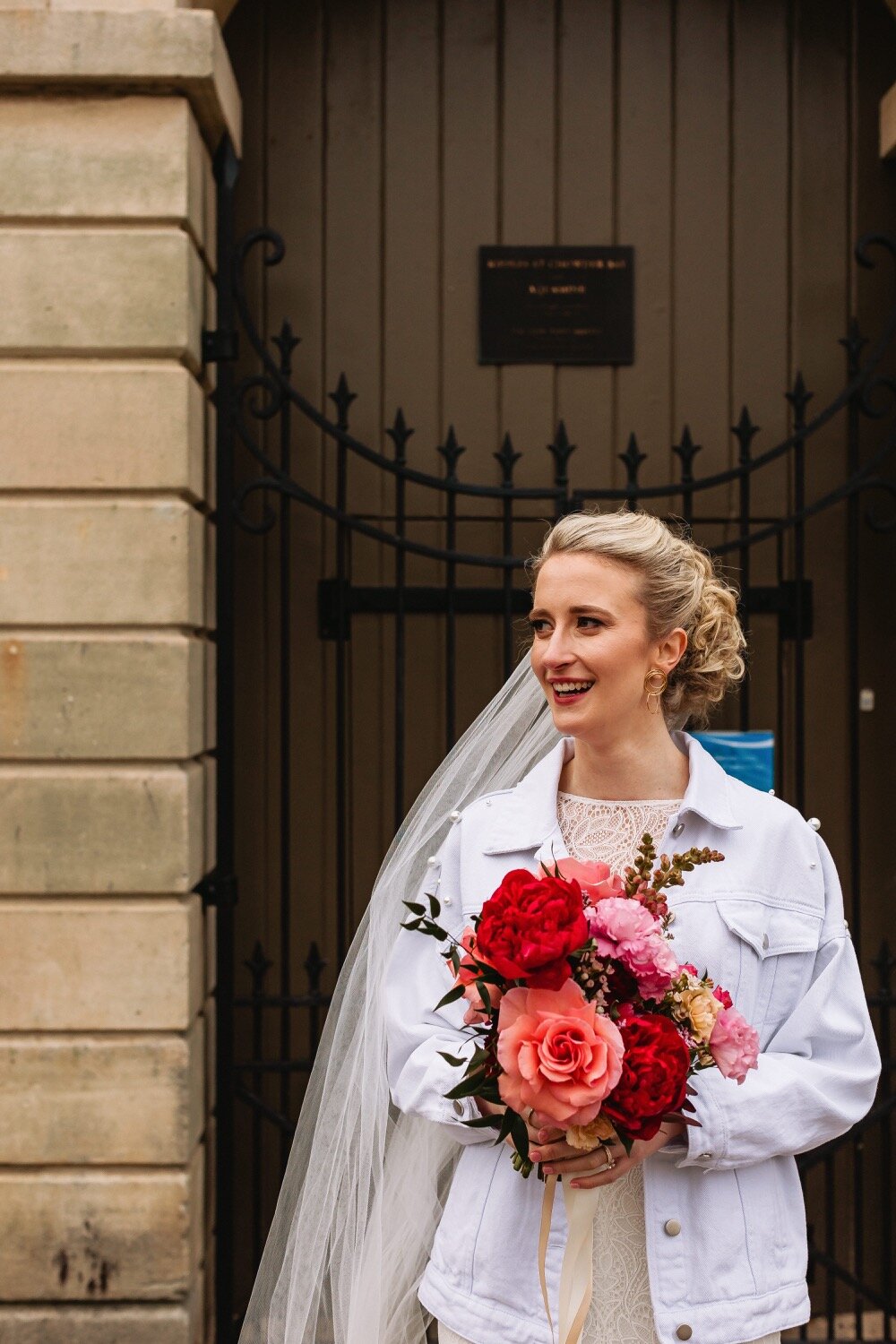 bride wearing white jacket holding flowers sydney