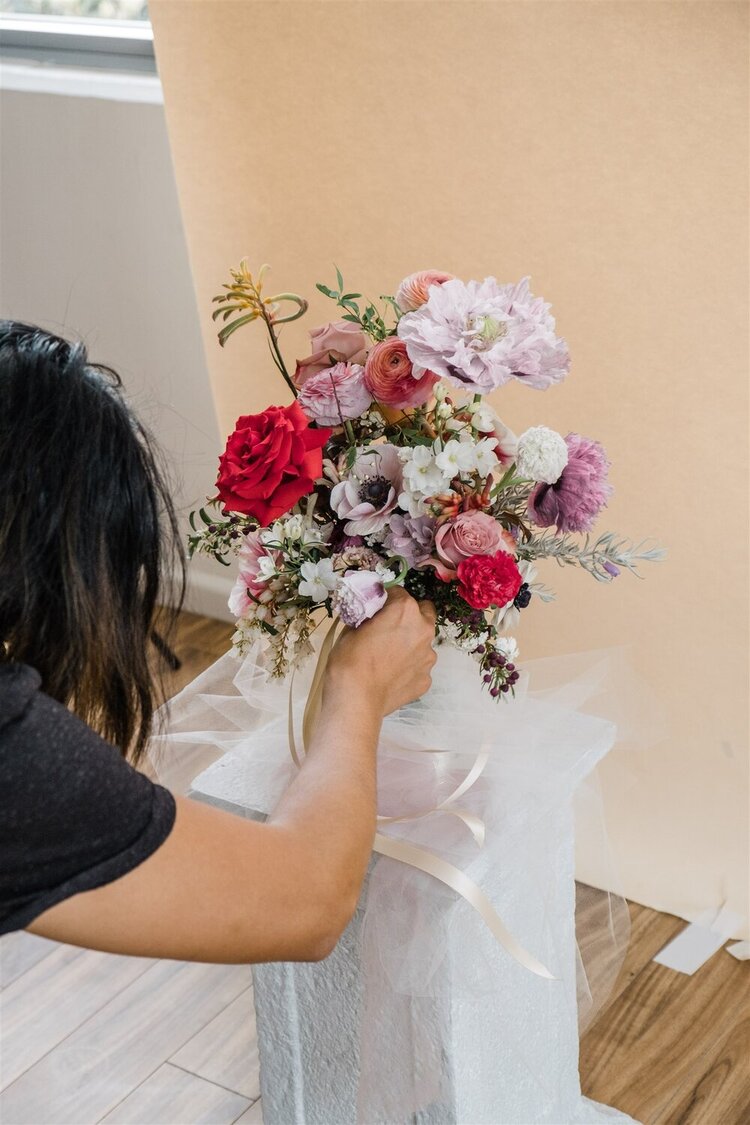tweaking bridal bouquet design to style shoot in workshop