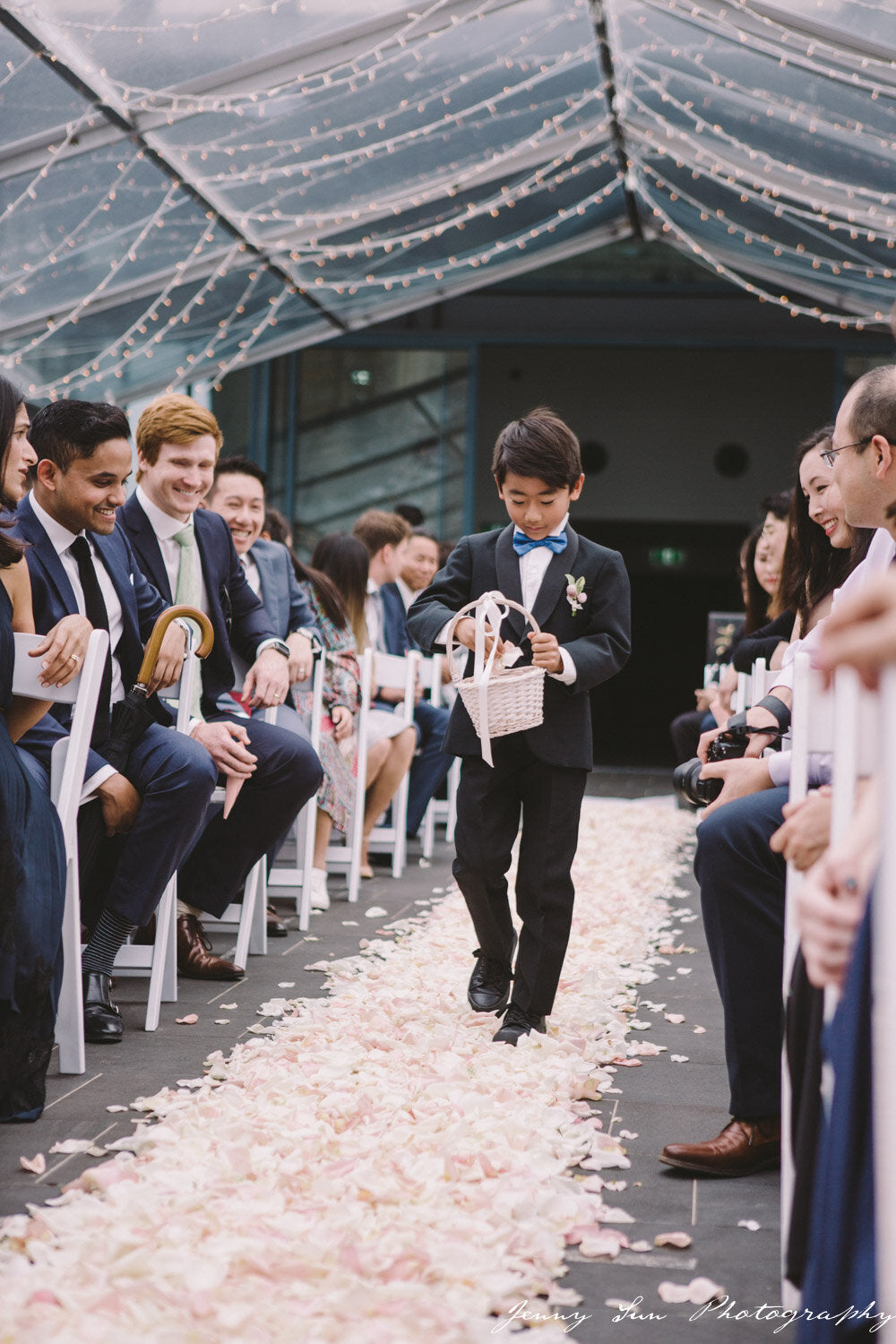 page boy walking down the aisle throwing petals