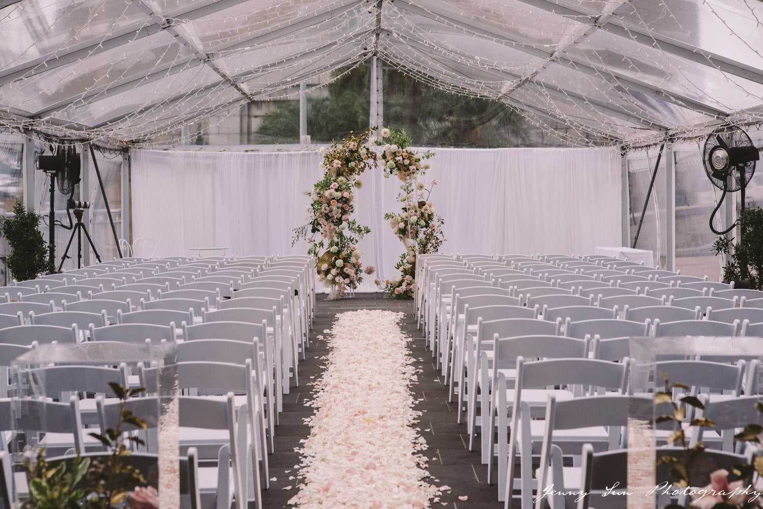 pier one marquee ceremony wedding with floral arch and rose petals