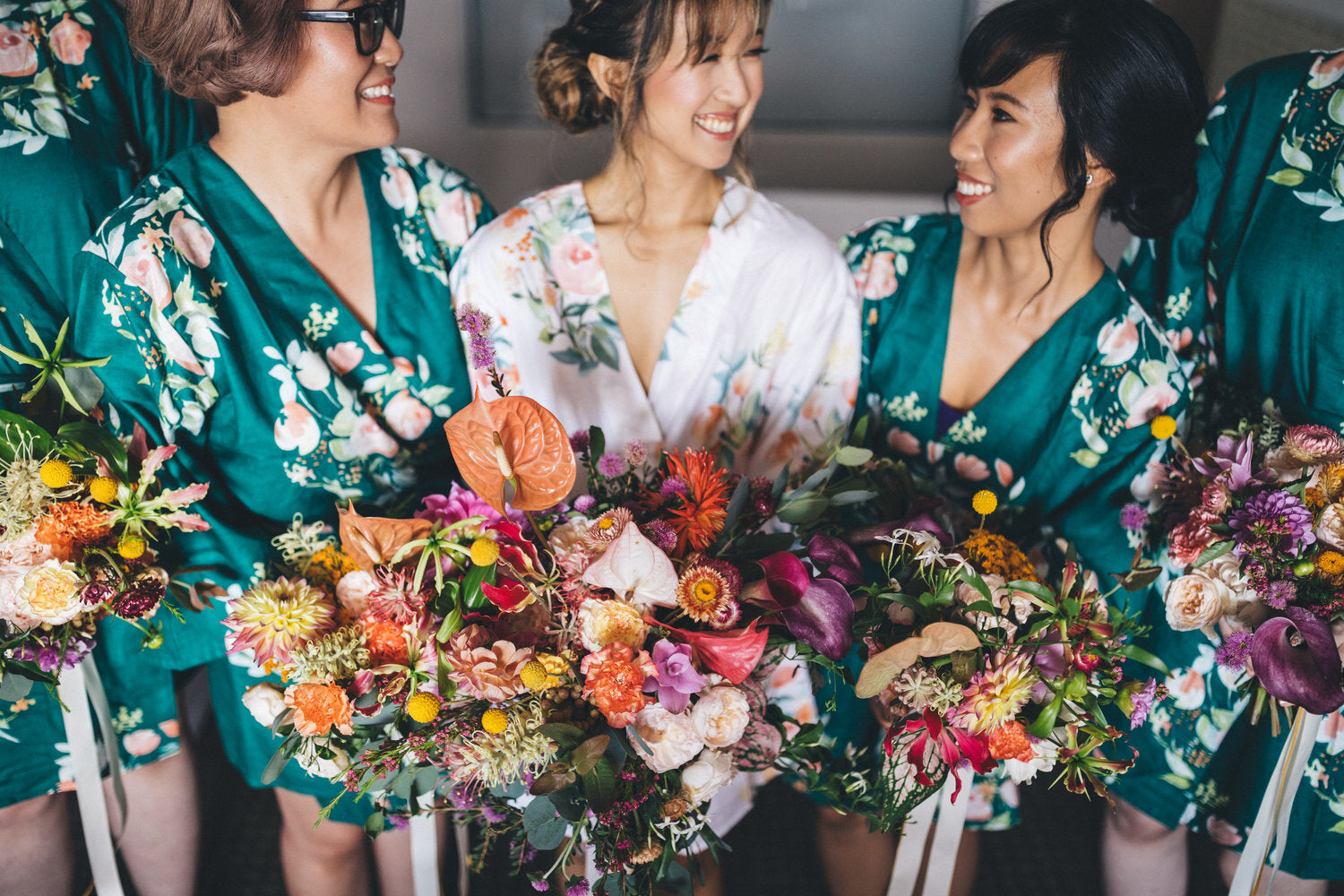 bride with bridesmaids holding colourful wedding bouquets