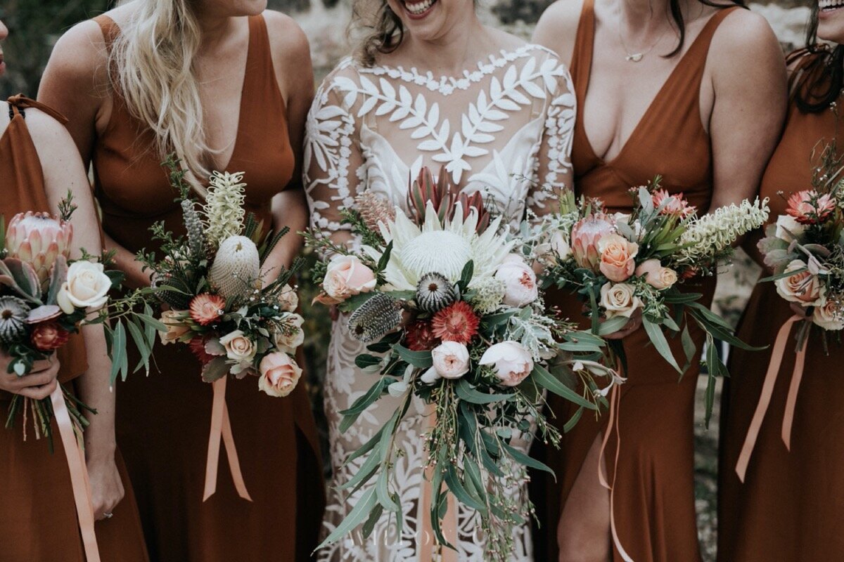 bride with bridesmaids bridal party holding rustic native flowers