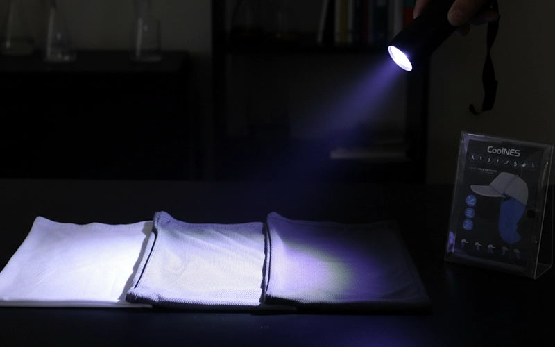 UV flashlight shining on different UPF fabric samples to show sun-blocking performance