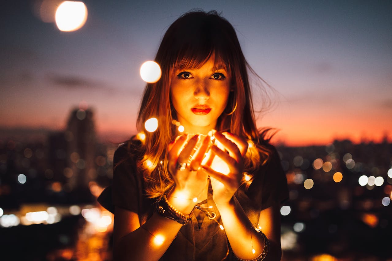 Woman holding fairy lights by Matheus Bertelli