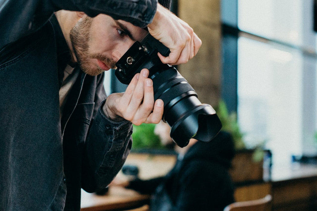 Man Holding Black Dslr Camera