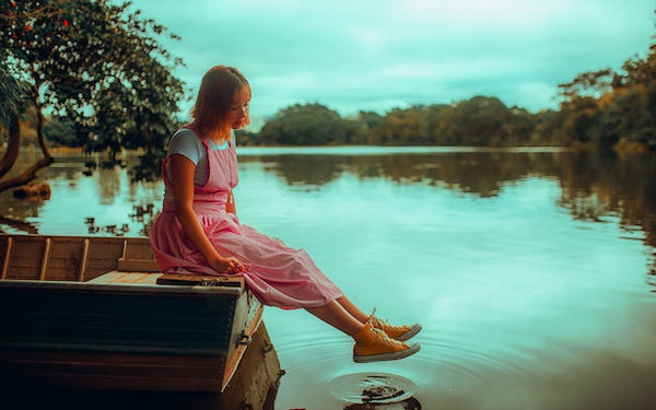 Young Woman in Pink Dress Sitting on Brown Boat