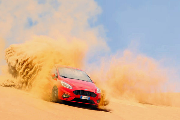 Car racing on dirt road