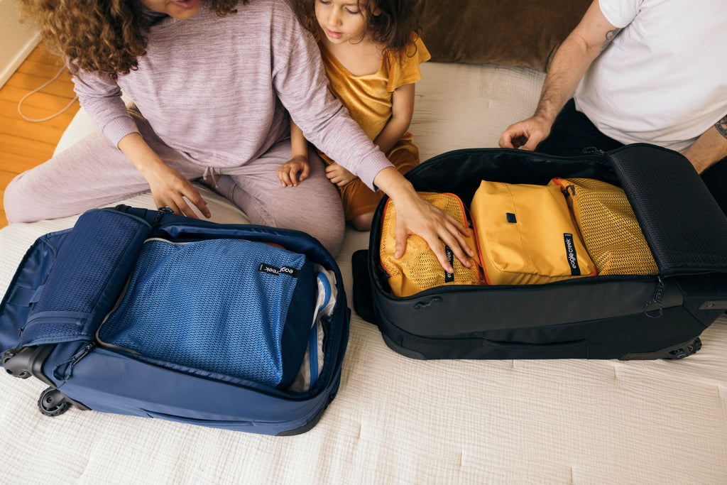 A family packs their carry-ons with packing cubes