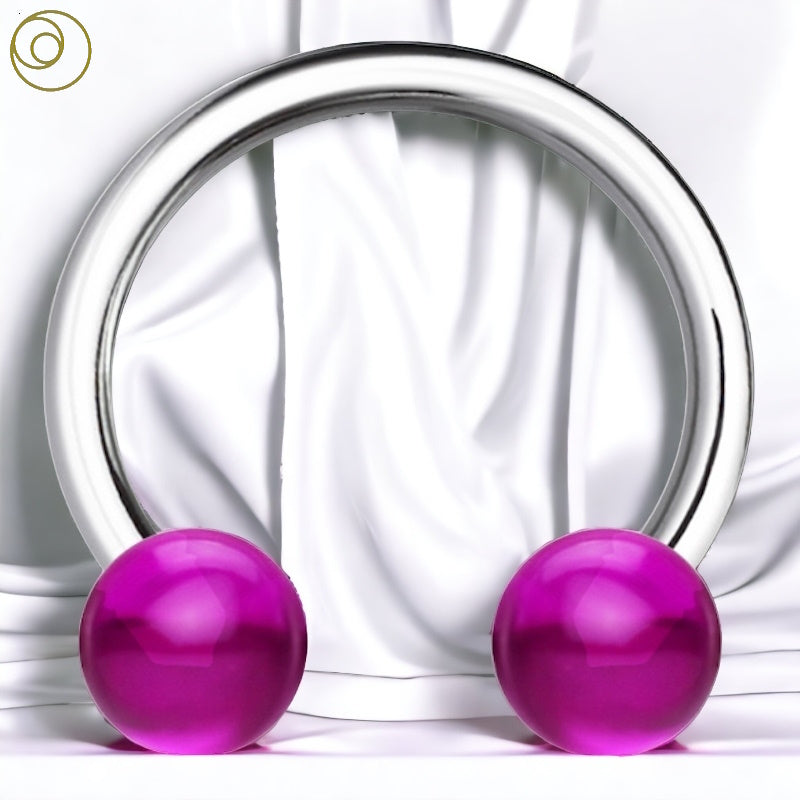 A 16 gauge horseshoe earring with purple balls pictured against a white fabric background.