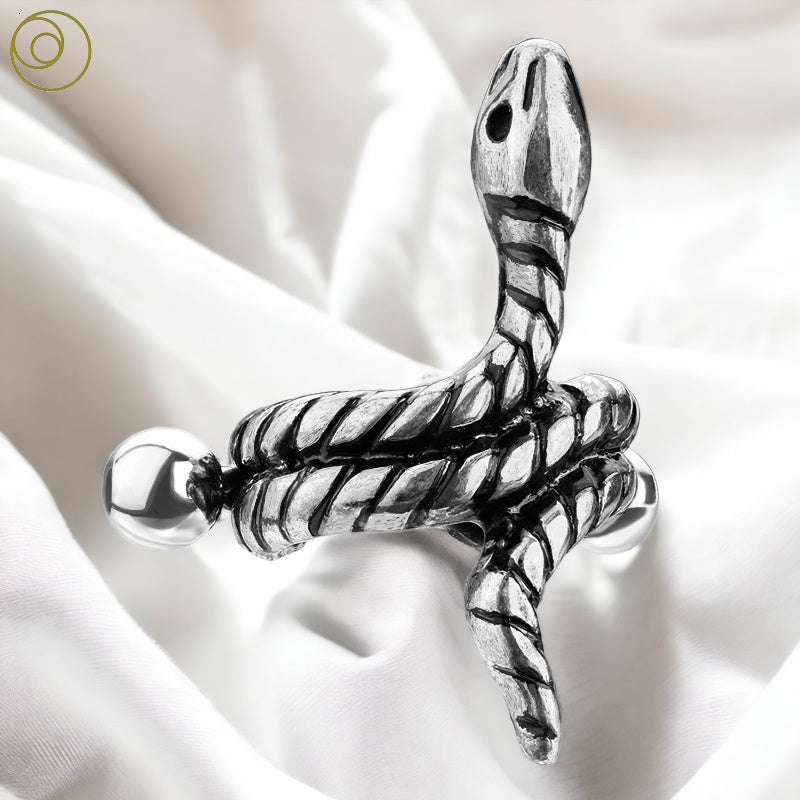 An antique silver snake helix earring with a surgical steel bar in the back pictured against a white fabric background.