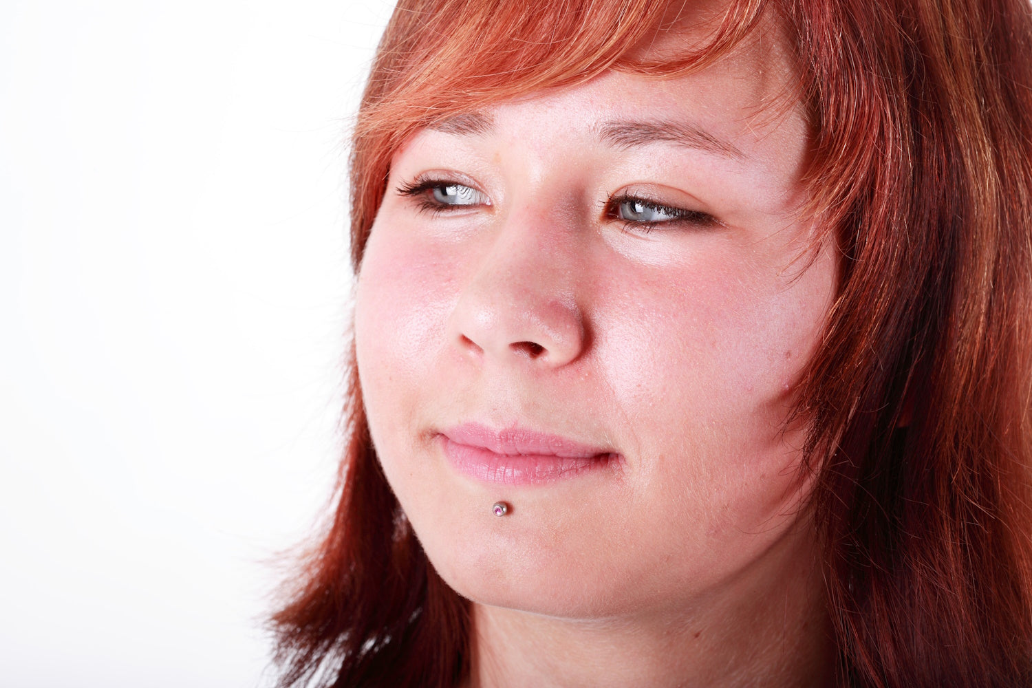 A female with a labret piercing pictured white a white background.