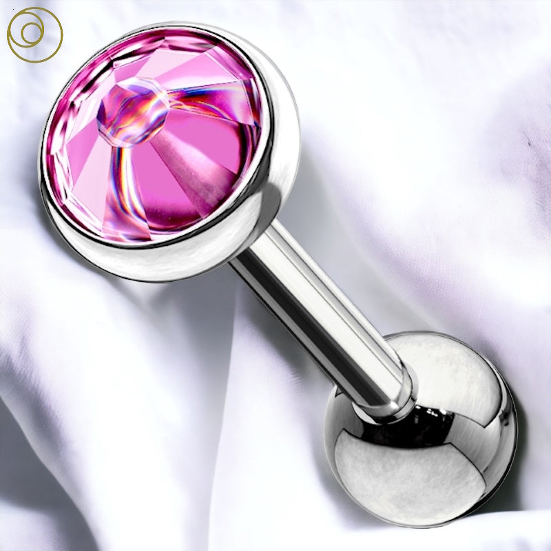 A fuchsia gem cartilage earring with a disc shaped gem on the top and a surgical steel bar with a ball on the bottom pictured diagonally against a white fabric background.