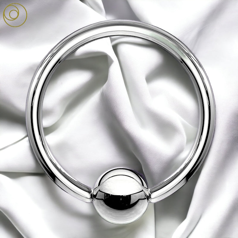 A 10 gauge 316L surgical steel captive bead ring pictured against a white fabric background.