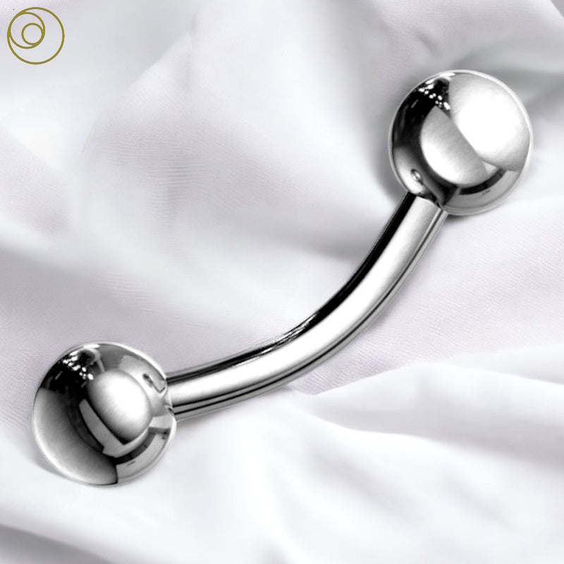 A surgical steel eyebrow piercing barbell that also works in a bridge piercing pictured against a white fabric background.