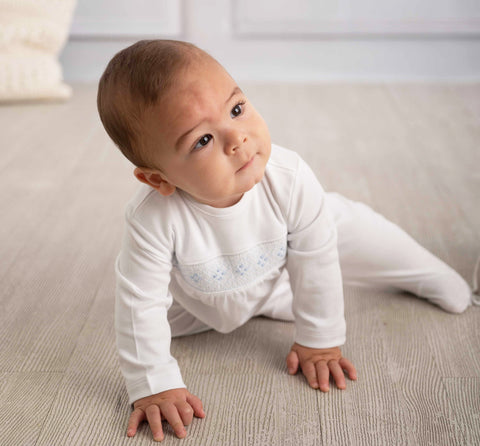 "Baby boy in white pima cotton footie, resting on the floor"