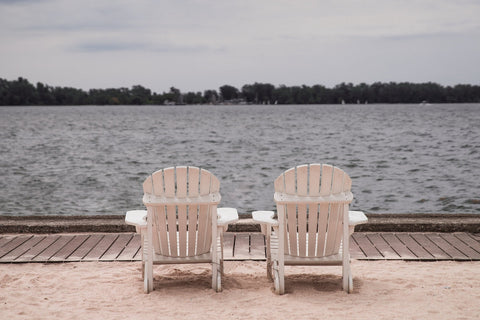 two adirondack chairs facing the ocean
