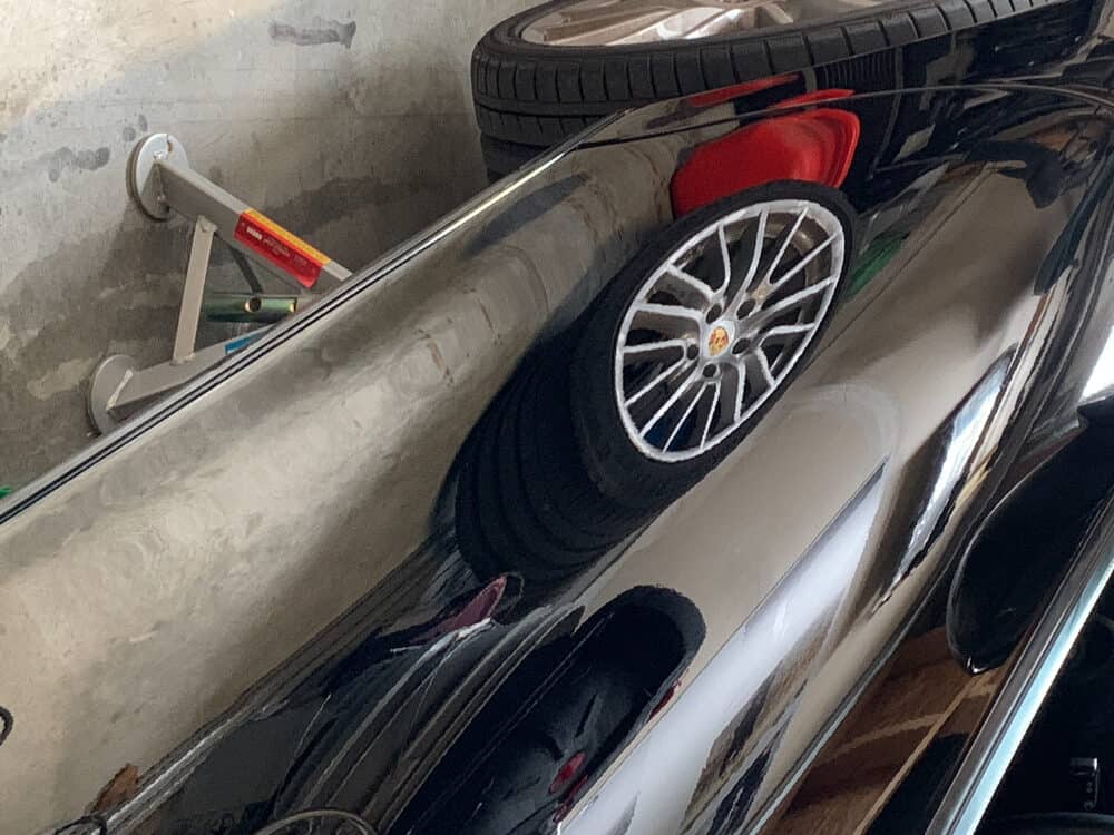 A car is parked in a garage with a tire on it.