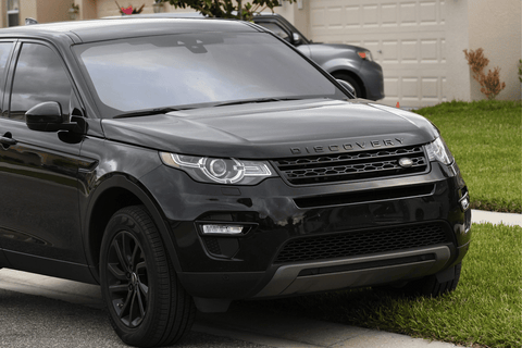 Sleek black Land Rover Discovery parked on street.