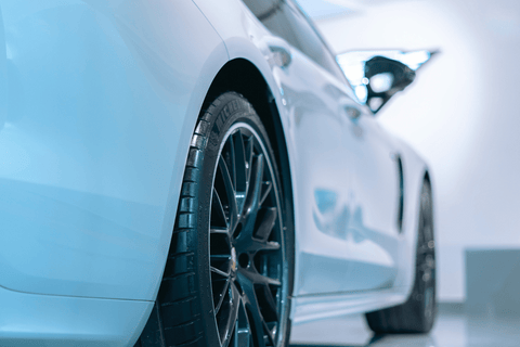 White sports car showcasing its stylish wheel and elegant front curves.