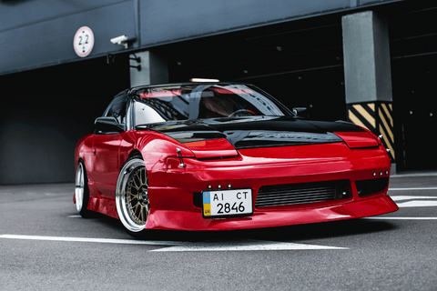 Red sports car with sleek design parked at an urban location.