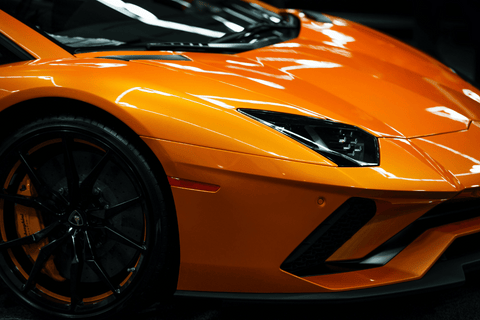 Close-up of a glossy orange luxury performance vehicle.