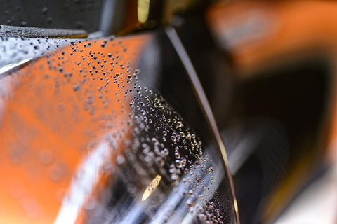 a close up of a car with water droplets on it