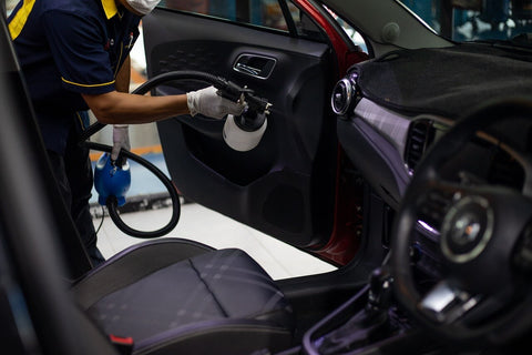 a person is spraying up the interior of a car