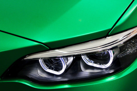 a close up of the headlights on a green car