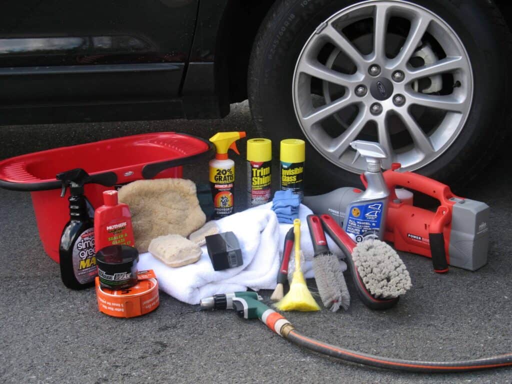 Car surrounded by many car cleaners.