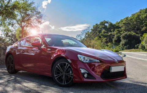 A gleaming Toyota car freshly cleaned and protected with a ceramic coating, showcasing a vibrant shine and reflection on its flawless surface.