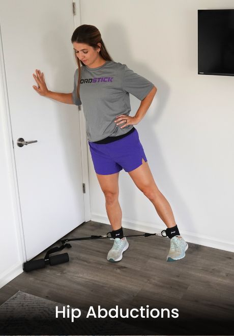 Person performing hip abductions with resistance band attached to a door.