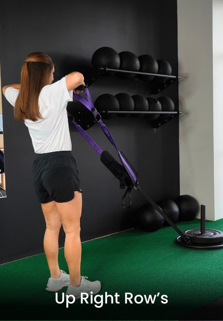 A person performs upright rows with resistance bands in a gym setting.