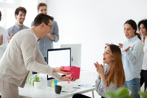 Group of people opening corporate gift in office