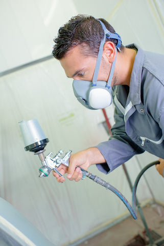 mechanic spraying car 