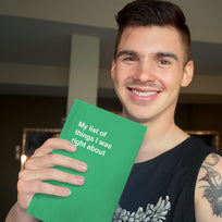 A young smiling man holding his WTF Notebook