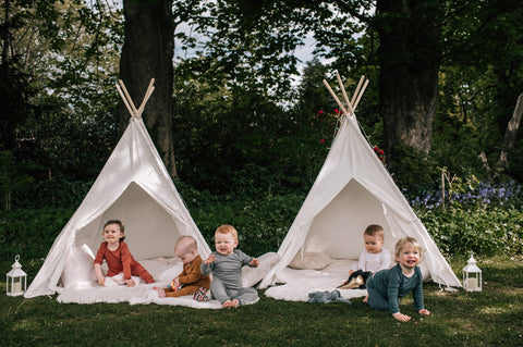 Babies outside wearing different colours of merino sleepwear.