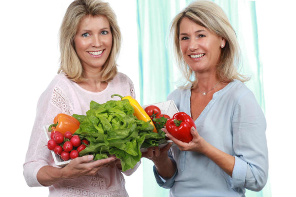 Two women in menopause with salads, fruits and vegetables eating a healthy diet