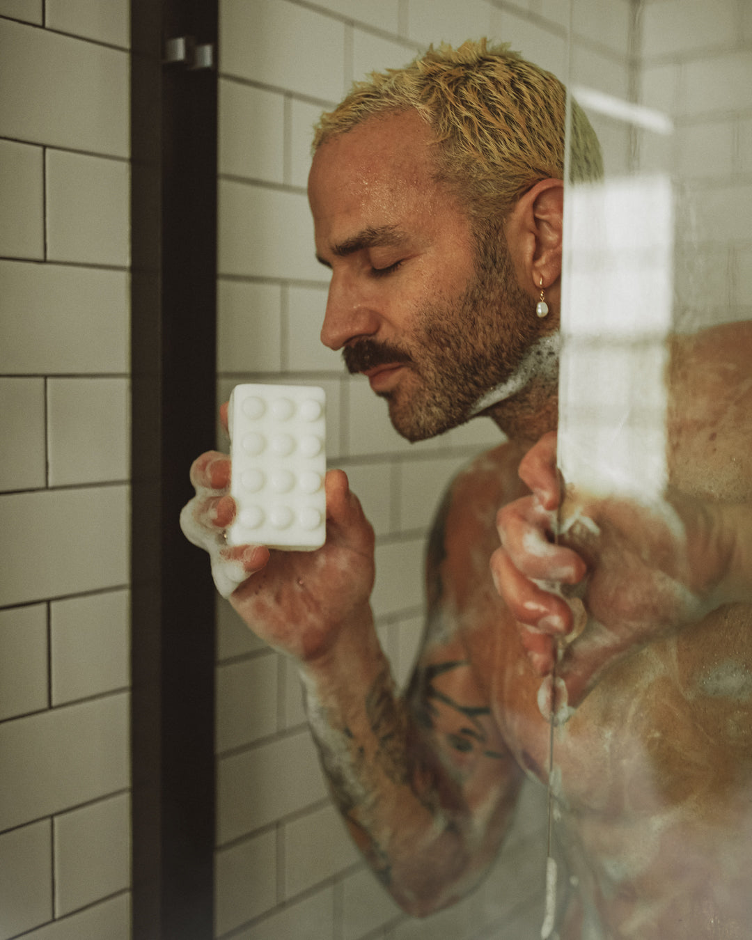 guy in shower holding bar soap